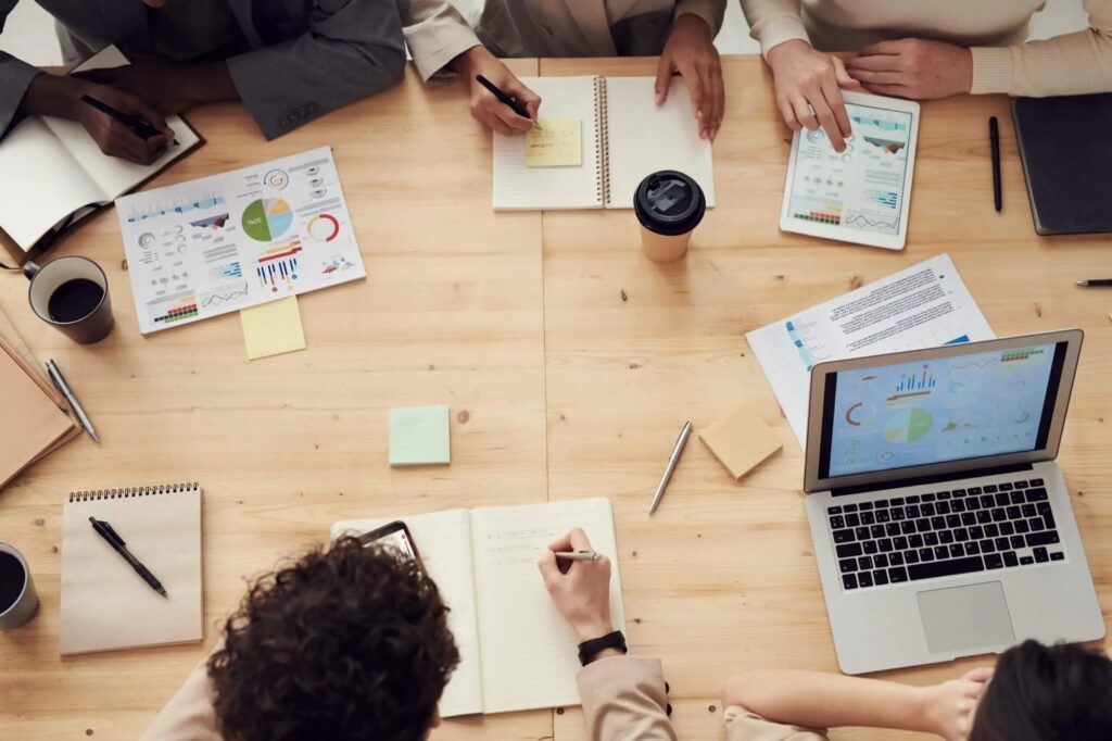 Equipo de trabajo revisando documentación de compliance en una mesa de reuniones
